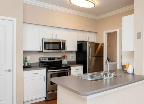 A kitchen with a stove, oven, refrigerator, and microwave.
