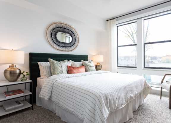 A bedroom with a large bed and a mirror on the wall.