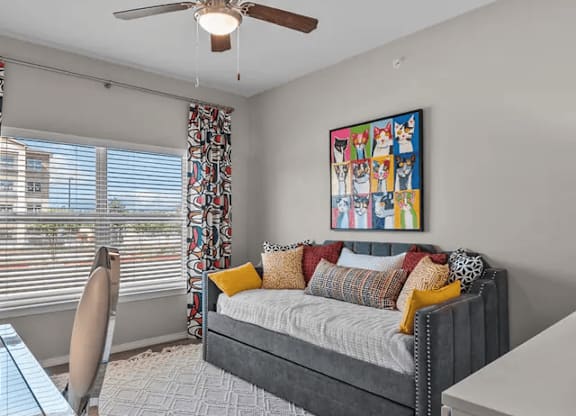 A bedroom with a bed, a chair, and a painting on the wall.
