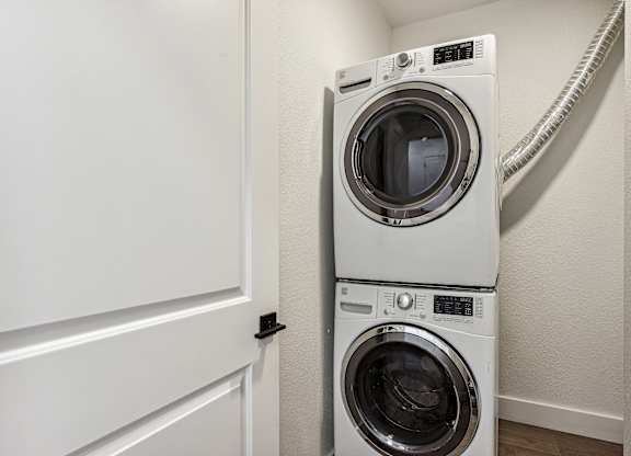 A white washing machine and dryer in a small laundry room.