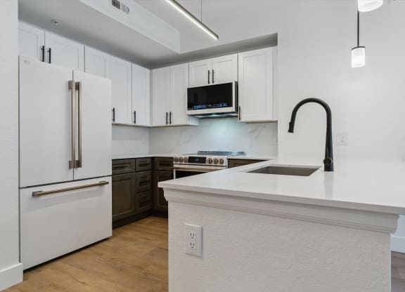 a kitchen with white cabinets and a white counter top