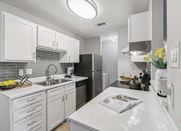 A kitchen with white cabinets and a white countertop.