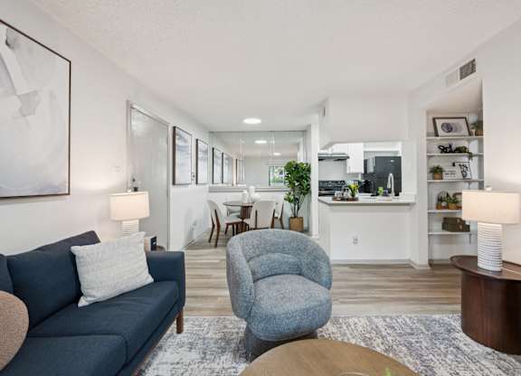 A living room with a blue couch and a grey armchair.