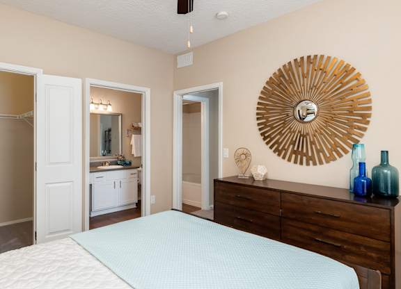 A bedroom with a bed, dresser, and mirror.