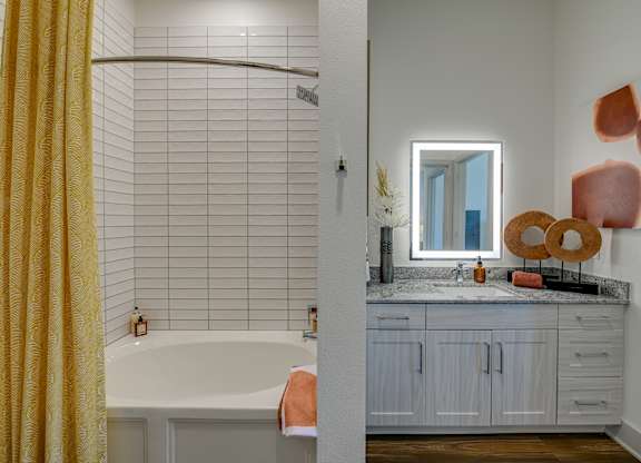 A bathroom with a yellow shower curtain and a white bathtub.