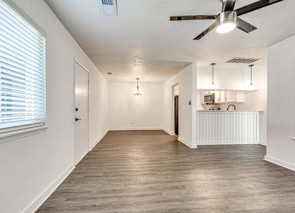 A room with a ceiling fan and light fixture.