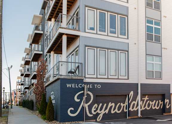 A building with a sign that says "Welcome to Reynoldtown" in front of it.
