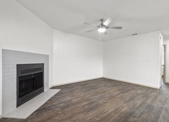 A room with a fireplace and a ceiling fan.