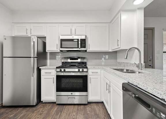 A kitchen with white cabinets and stainless steel appliances.