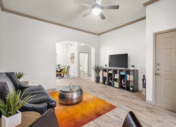 A living room with a black leather couch and a television.