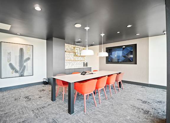 A conference room with a long table and chairs.