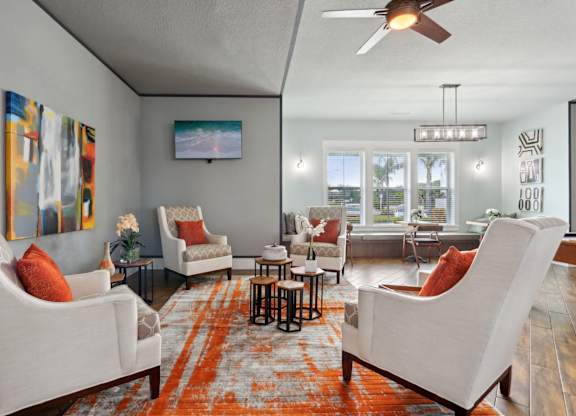 A living room with a white couch and orange pillow.