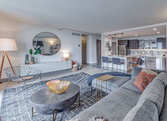 A modern living room with a grey sofa and a round coffee table.
