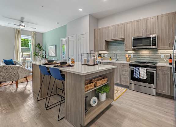 A modern kitchen with a bar area and a refrigerator.
