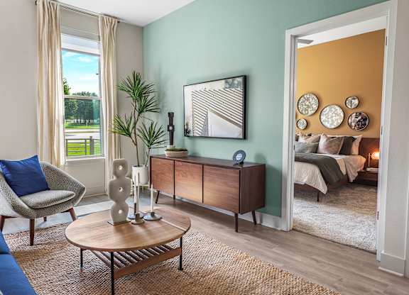 A living room with a chair, a table, and a cabinet.