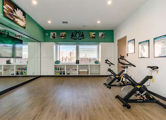 A room with exercise bikes and pictures on the wall.