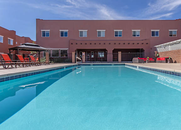 A large swimming pool in front of a red building.