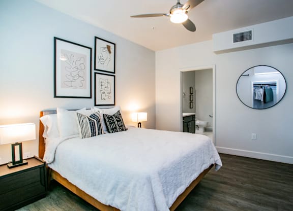 A bedroom with a bed, nightstands, and a mirror.