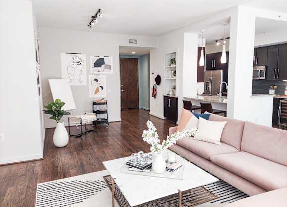 A living room with a couch, coffee table, and a plant.