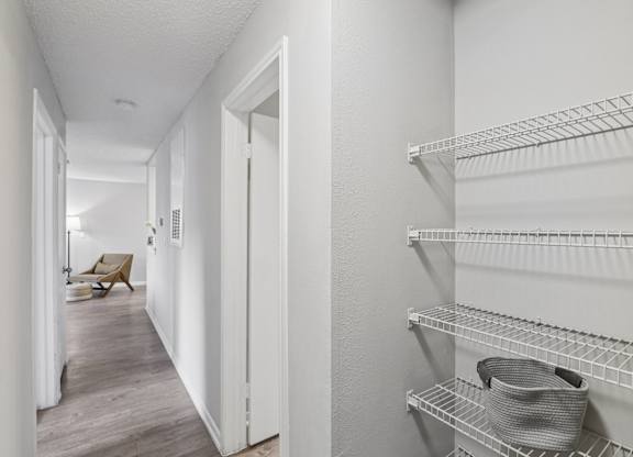 A hallway with a shelf on the right side.