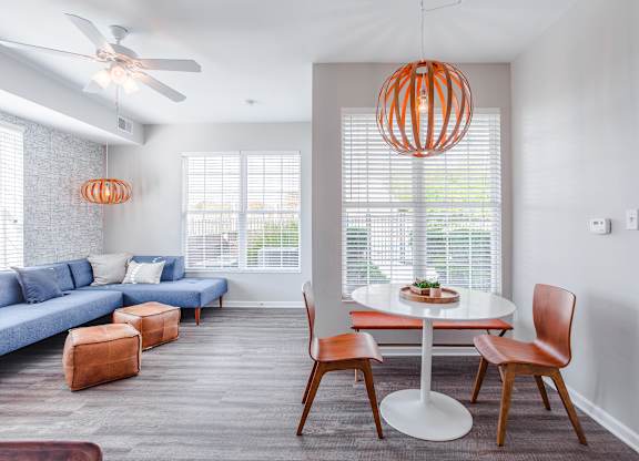 A modern living room with a blue couch and a white dining table.