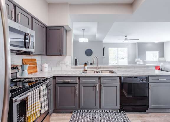 A modern kitchen with dark brown cabinets and a white countertop.