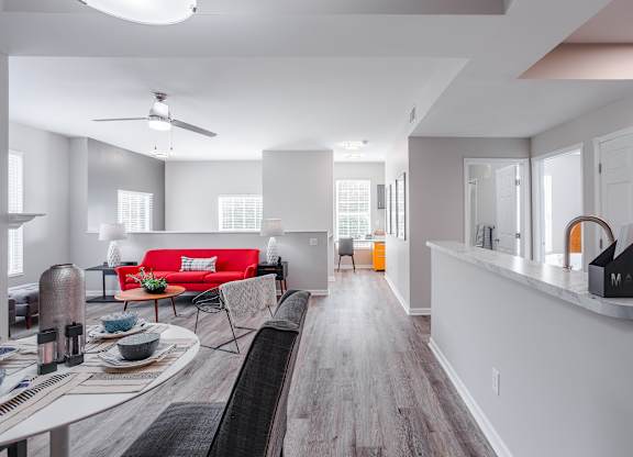 A modern living room with a red couch and a wooden floor.