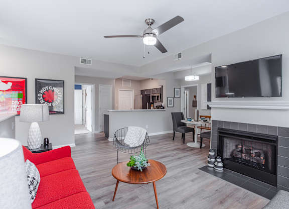 A living room with a red couch and a fireplace.