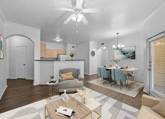 a living room and dining room with a table and a ceiling fan