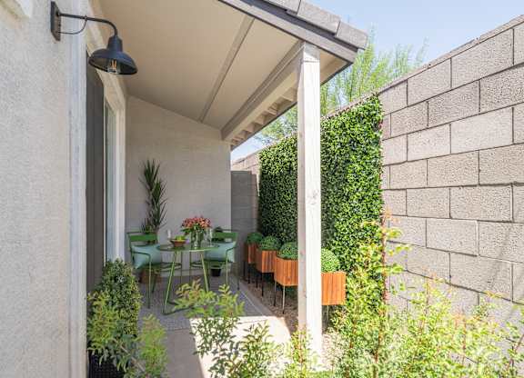 A patio with a table and chairs is covered by a white awning.