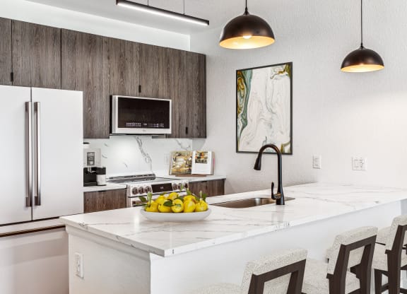 a kitchen with a white counter top with a bowl of fruit