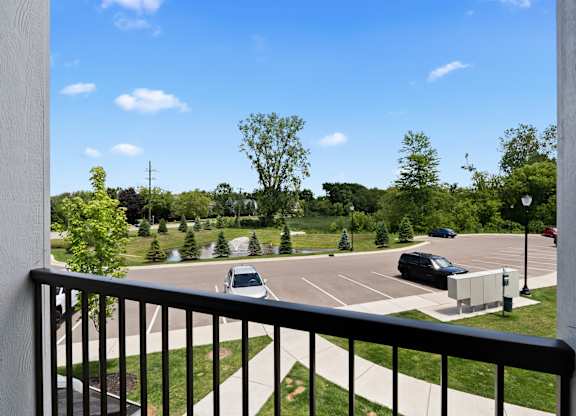 A parking lot with cars and trees in the distance.