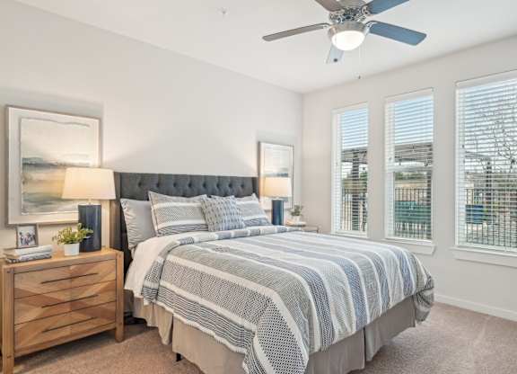 A bedroom with a large bed and a ceiling fan.