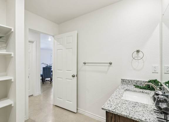 A white bathroom with a sink and a mirror.