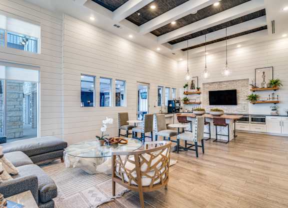 A modern kitchen and dining area with wooden floors and furniture.