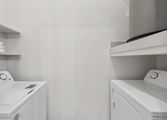 A white washing machine and dryer in a laundry room.