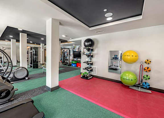 A gym with a red mat in the middle of the room.