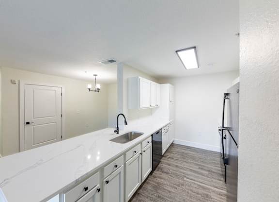 A kitchen with white countertops and a sink.