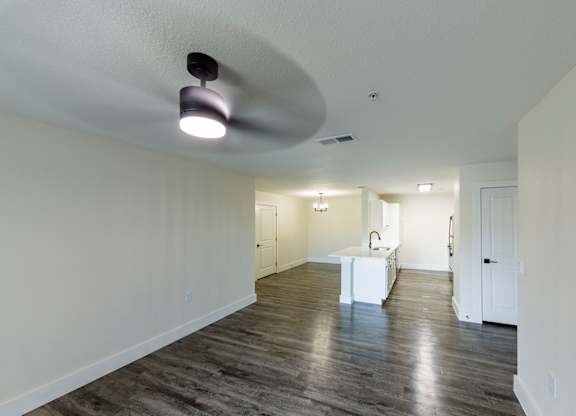 A spacious room with a white table and a light fixture on the ceiling.