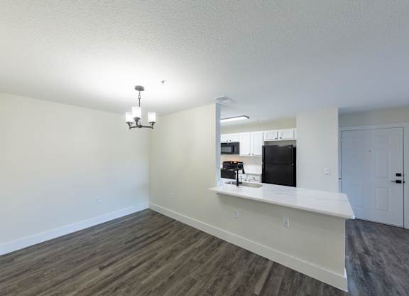 A kitchen area with a counter and a fridge.