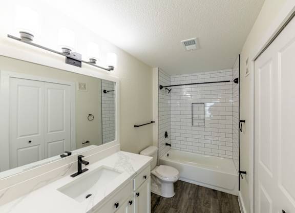 A white bathroom with a sink, toilet, and bathtub.