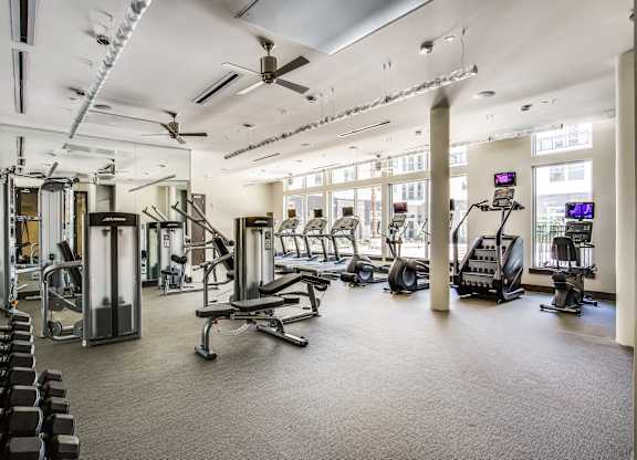 A spacious gym with a variety of equipment including treadmills, weights, and exercise machines.