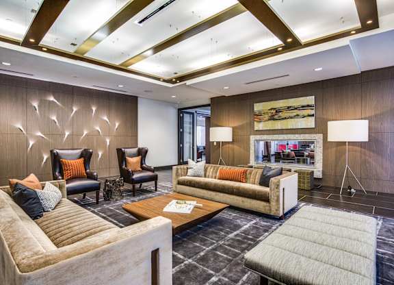 A modern living room with a large couch, two chairs, and a coffee table.