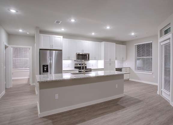 A kitchen with white cabinets and a refrigerator.