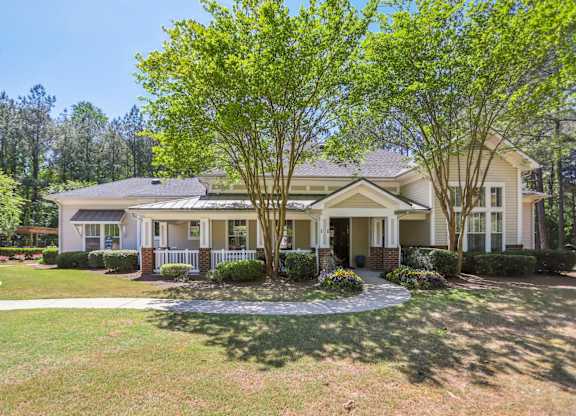 A house with a front yard and a tree in front.