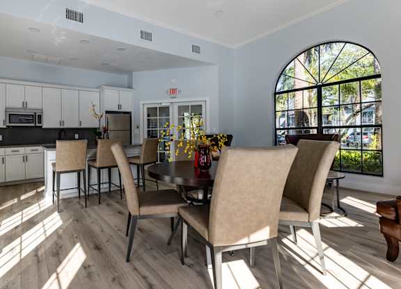 A dining room with a table and chairs.