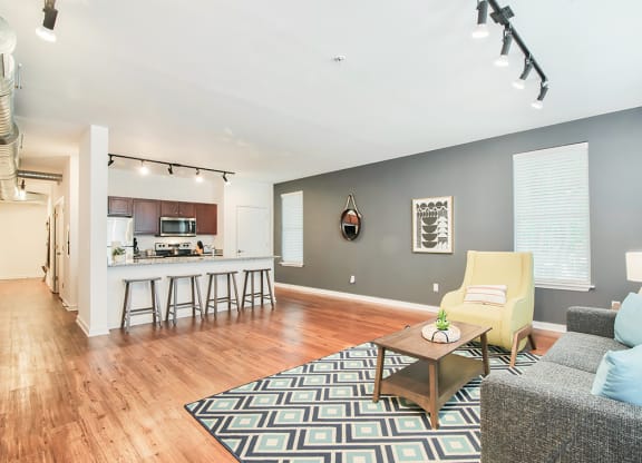 a spacious living room with a kitchen in the background
