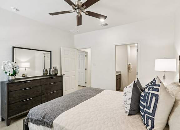 A bedroom with a bed, dresser, and mirror.