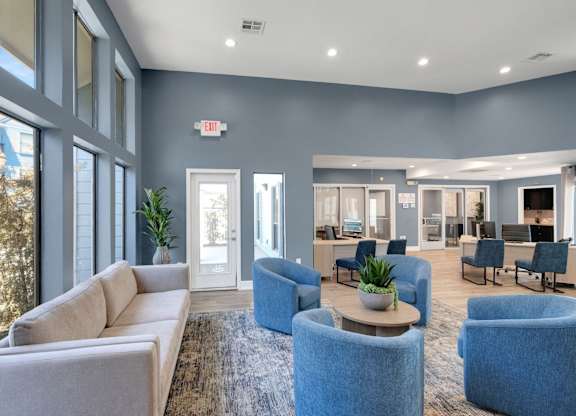 A spacious waiting room with a mix of blue and beige furniture.