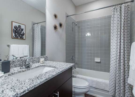 A bathroom with a white sink and a white toilet.